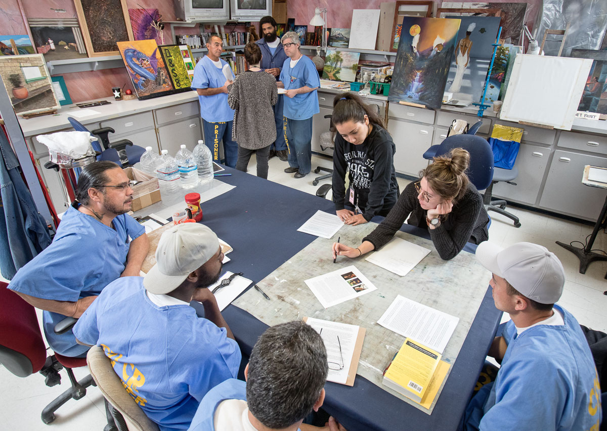 Student interns gather with participating artists to discuss their work and share ideas at California State Prison, Los Angeles County.